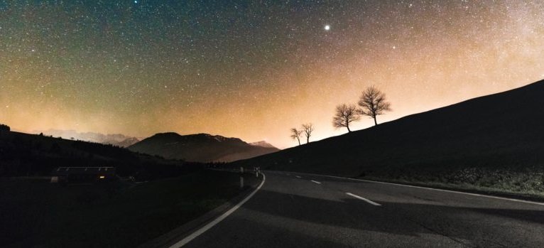 Een sterrenhemel boven een autoweg