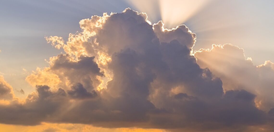 Zon die achter een donkere wolk schijnt