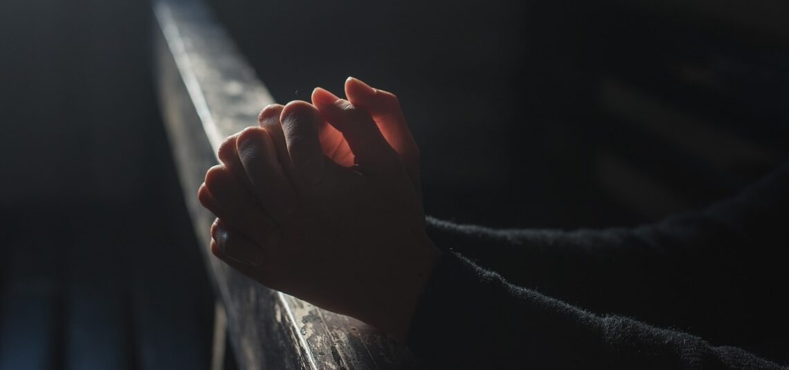 Twee gevouwen handen in het donker