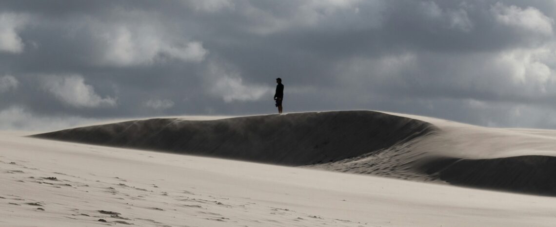 Man die eenzaam staat op een zandvlakte