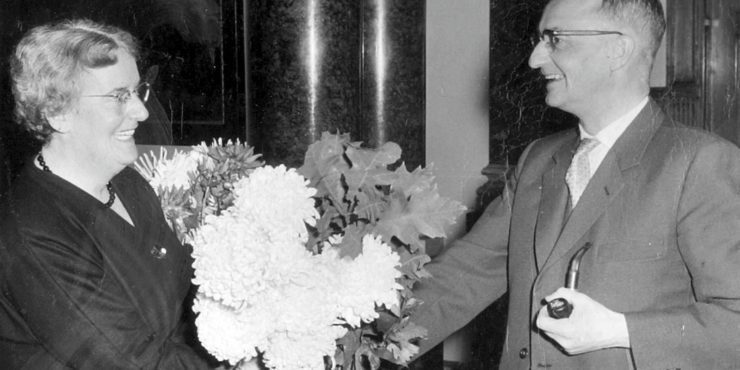 Arnold van Ruler die bloemen overhandigt aan zijn vrouw, bij het afronden van haar studie rechten in 1963