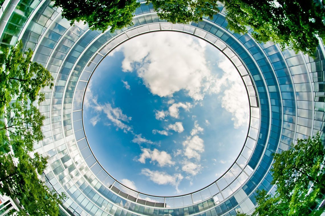omhoogkijkend naar de lucht in de open plaats van een modern kantoorgebouw