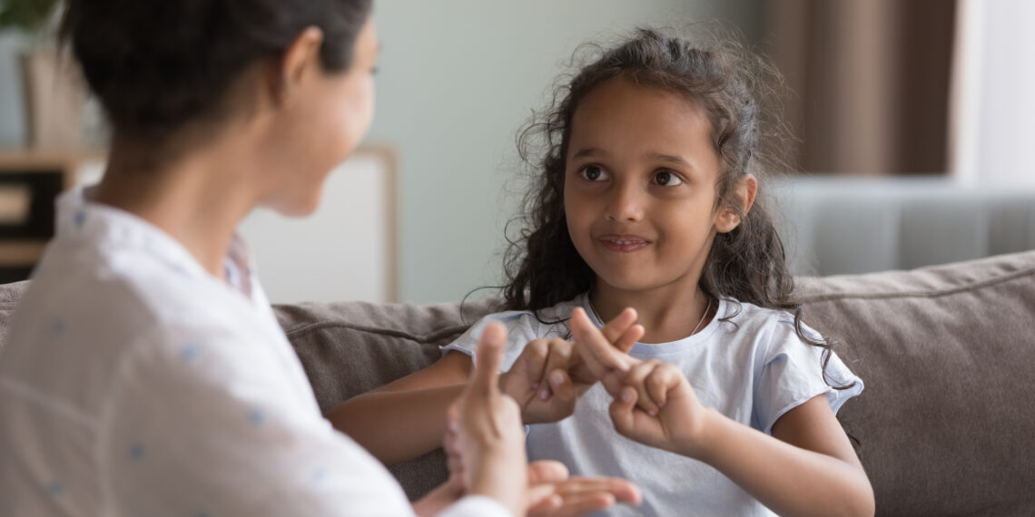 Jong meisje die met haar moeder communiceert door middel van gebaren taal.