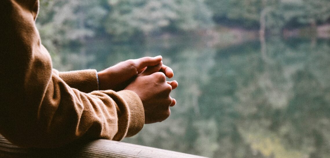 Man leunend over een balustrade
