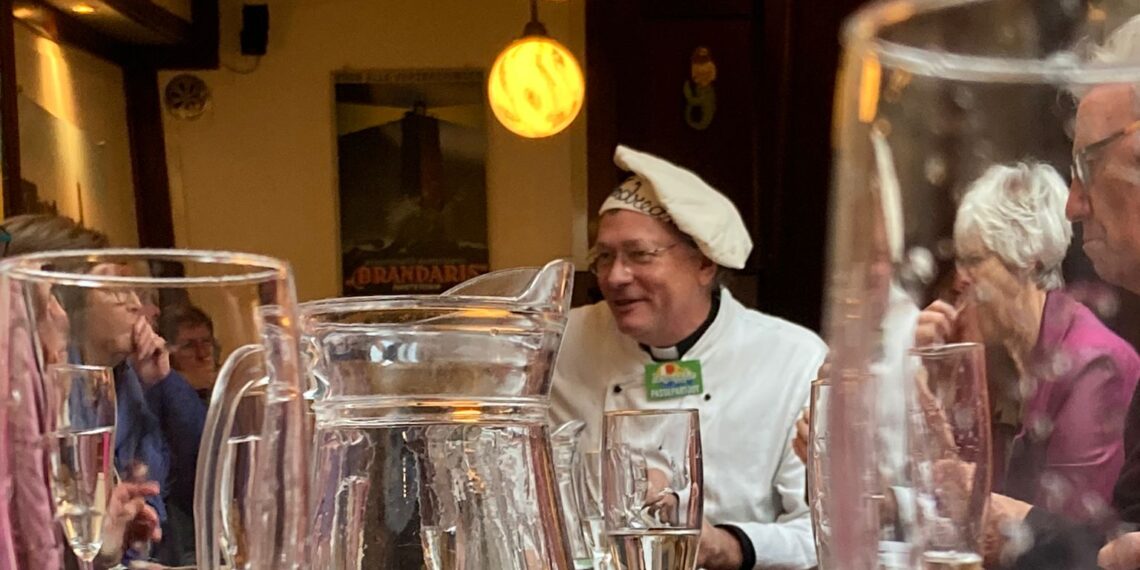 Een restaurant met op de achtergrond een man met een koksmuts.