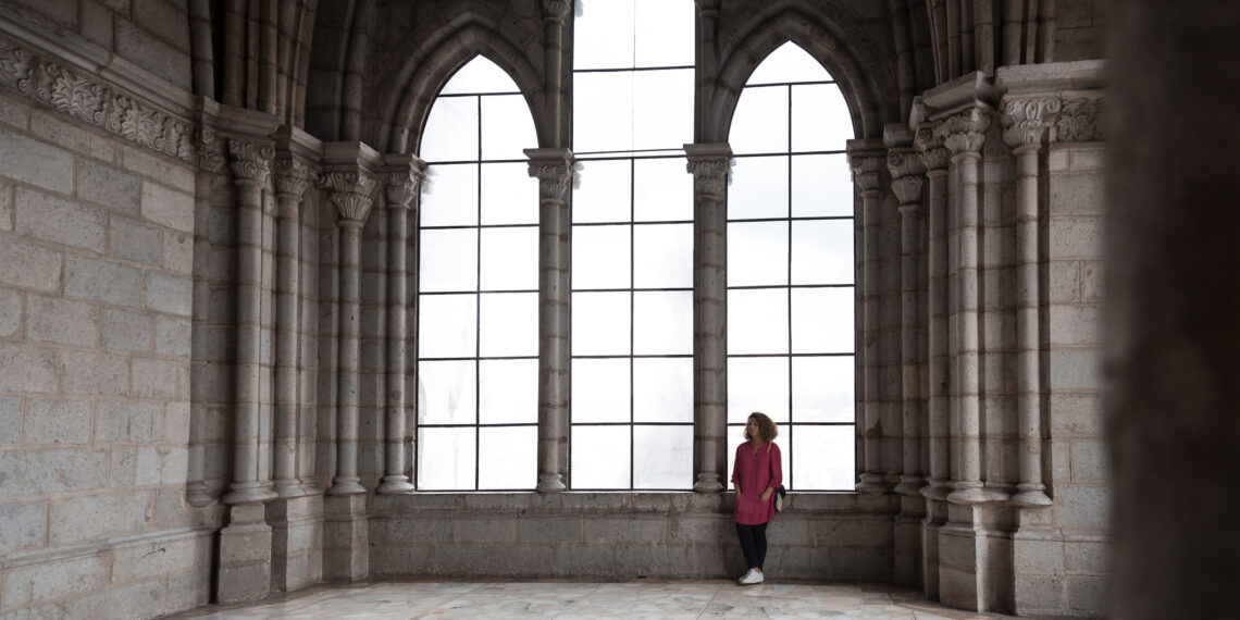 Vrouw in de kerk Eenzame vrouw die staat in een lege kerk