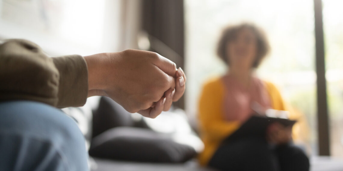 Twee mensen die een gesprek voeren Twee mensen die een gesprek voeren op een bank in een woonkamer