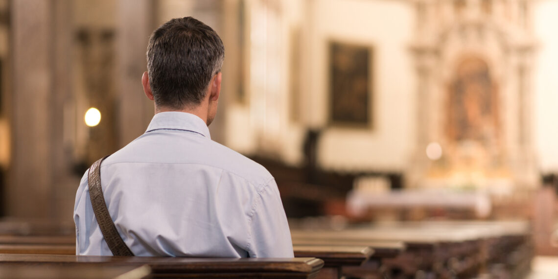 Man zittend in de kerkbanken