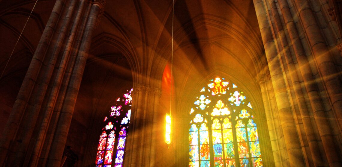 Leven in het licht van Gods koninkrijk Licht dat schijnt door hoge glad-in-lood ramen van een kerk