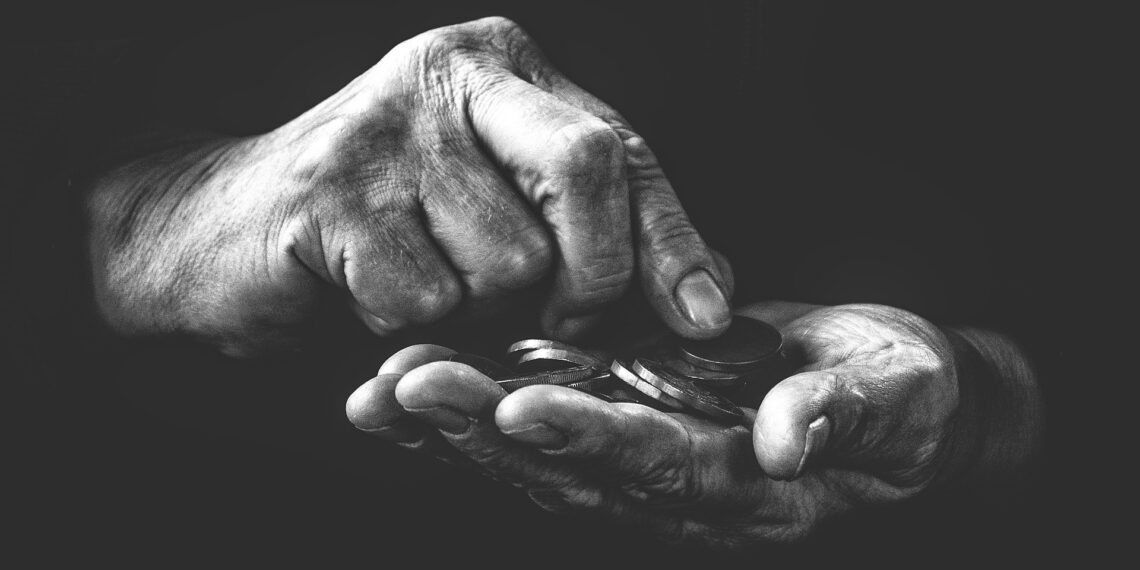 Hand met geld Onderbelichte hand met daarin muntgeld