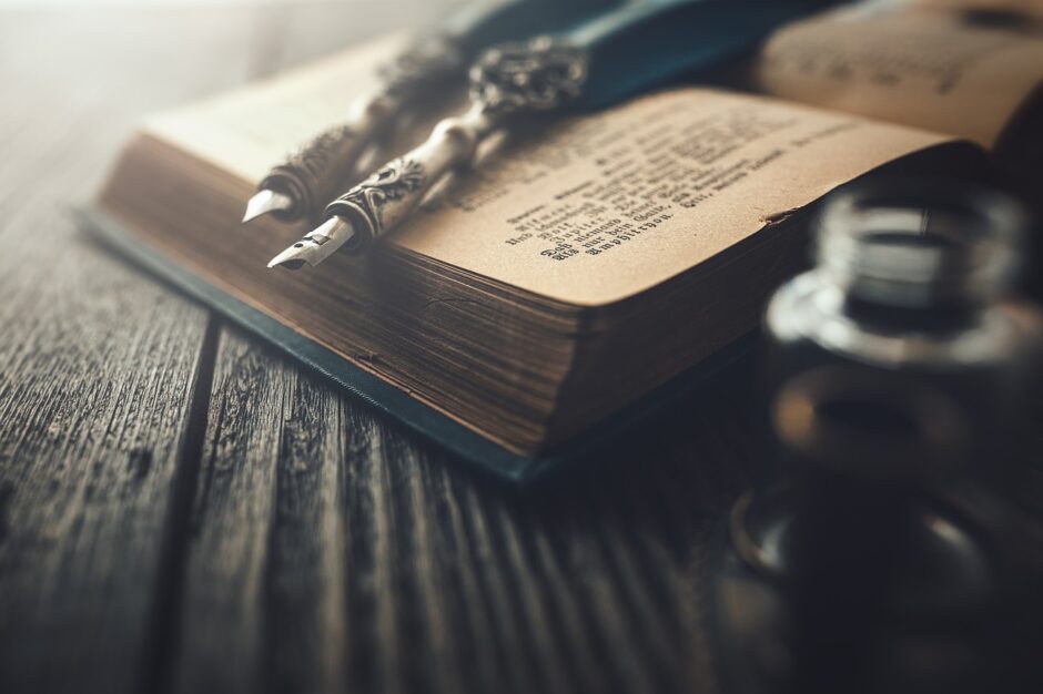 Een oud boek met vulpennen en inktpot