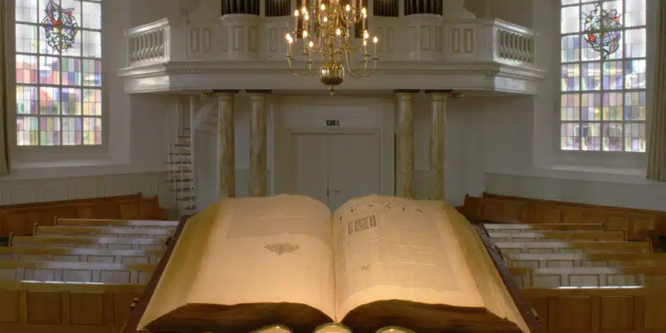 Een kanselbijbel die opengeslagen voorin een kerk ligt
