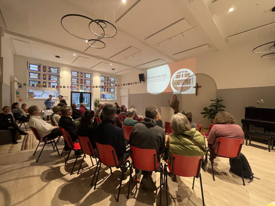 Mensen luisteren naar de lezing ‘Een bloeiende stad’ in Hebron