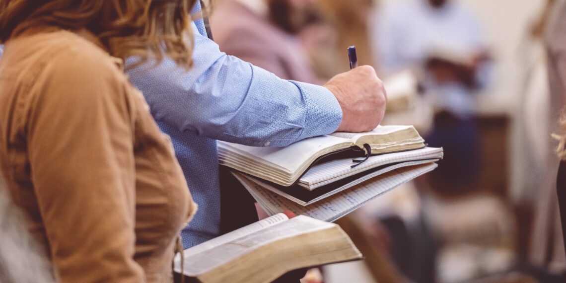 Mensen in de kerk Mensen in de kerk die een Bijbel vast hebben