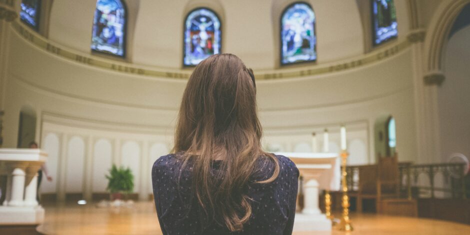 vrouw die voor het liturgisch centrum in een kerk zit