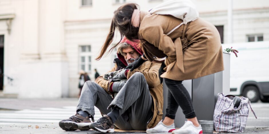 Jonge vrouw helpt dakloze man
