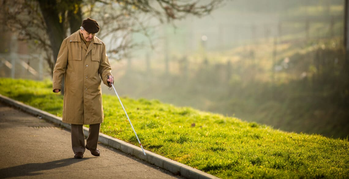 Blinde man die over een weg loopt