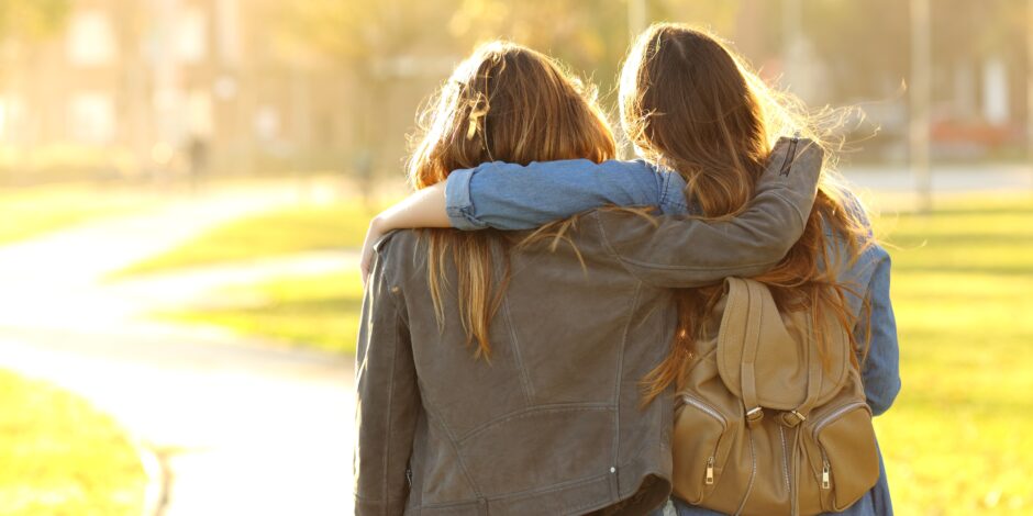 Twee vrouwen die een arm over elkaar heen slaan