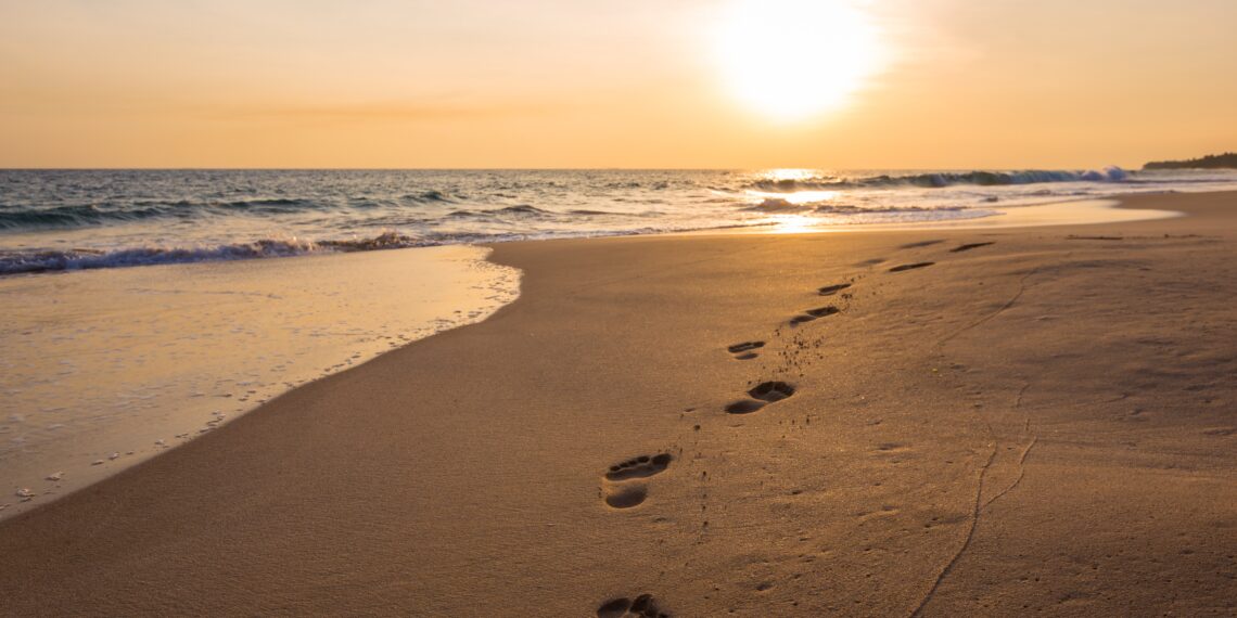 Strand Voetstappen op het strand bij zonsondergang