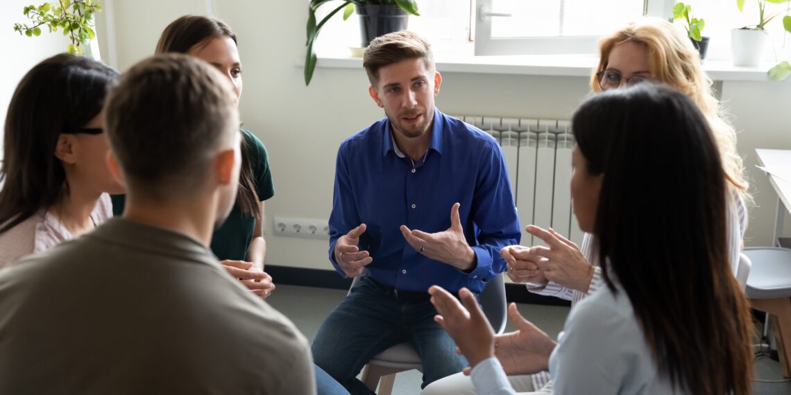 Groep mensen in gesprek Groep mensen die in een kring zitten en in gesprek zijn met elkaar