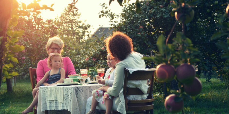 Gezin die aan het eten is in een boomgaard