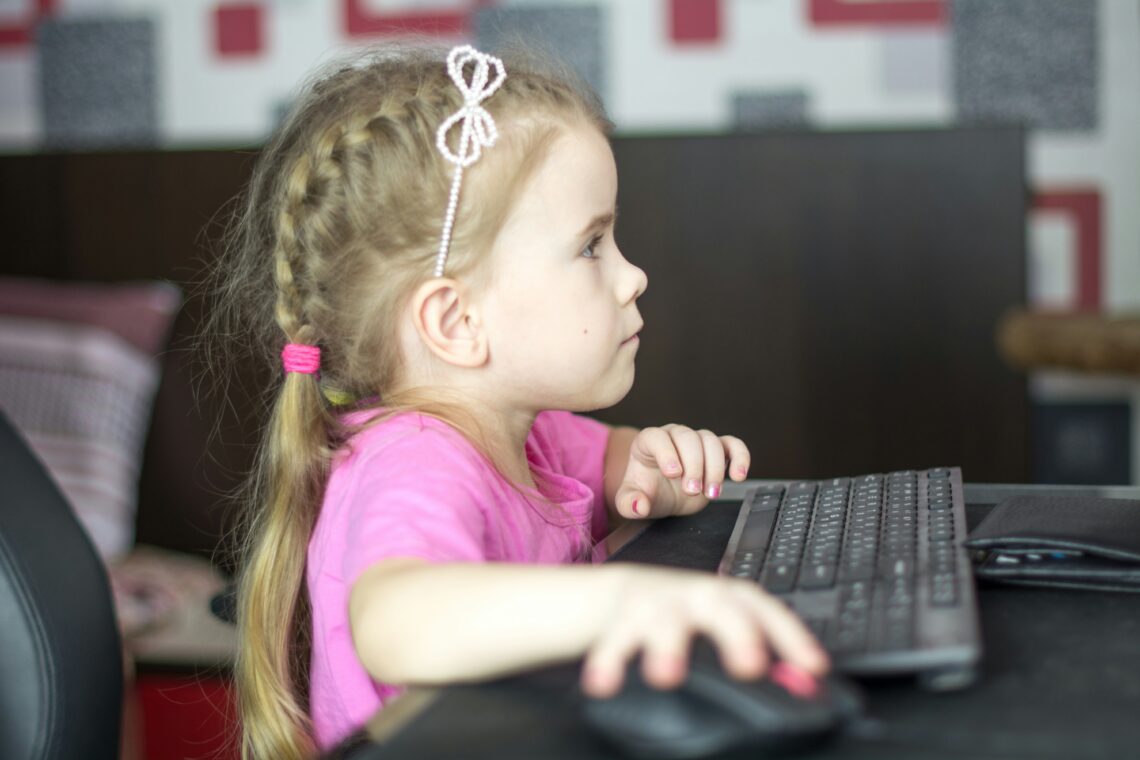 Kind die achter de computer zit
