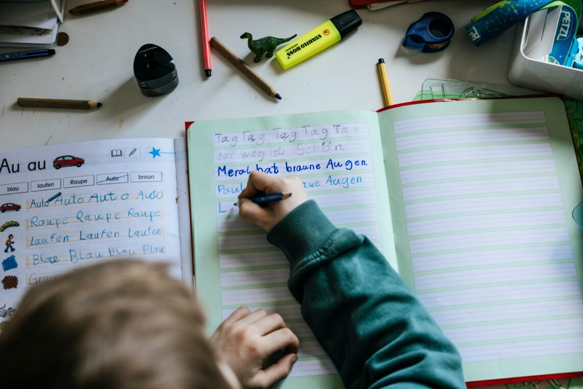 Kind die aan het schrijven is in zijn schrift