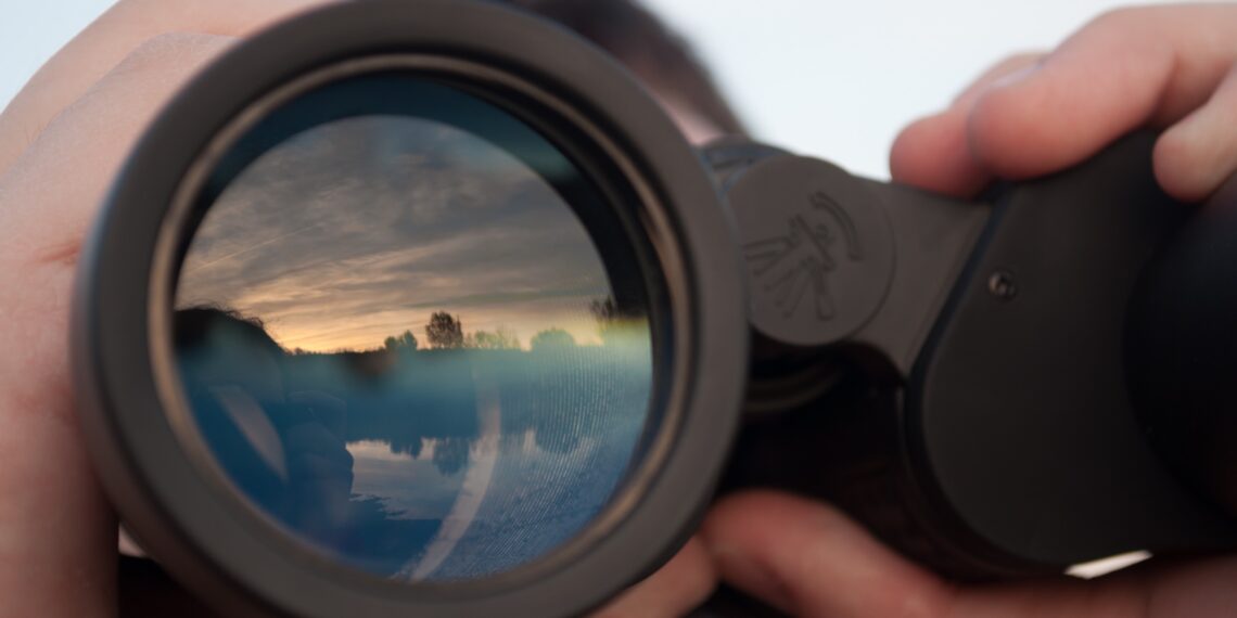Iemand die door een verrekijker kijkt