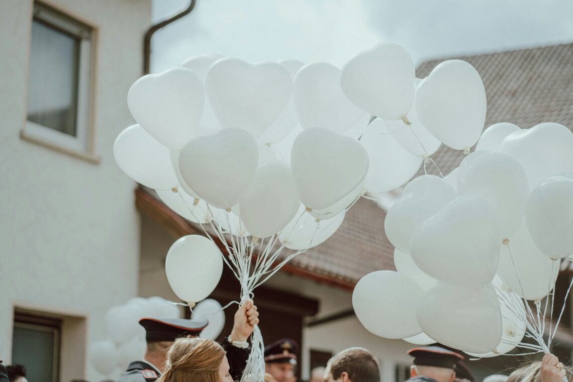 Mensen die witte ballonnen op straat vasthouden