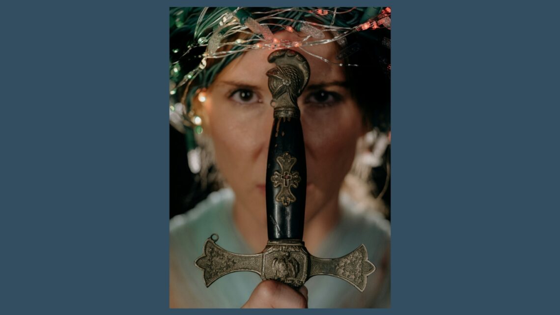 Vrouw die een zwaard voor haar hoofd houdt