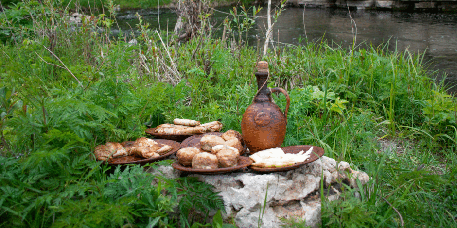Bordjes eten die op een steen staan midden in het gras aan een rivier