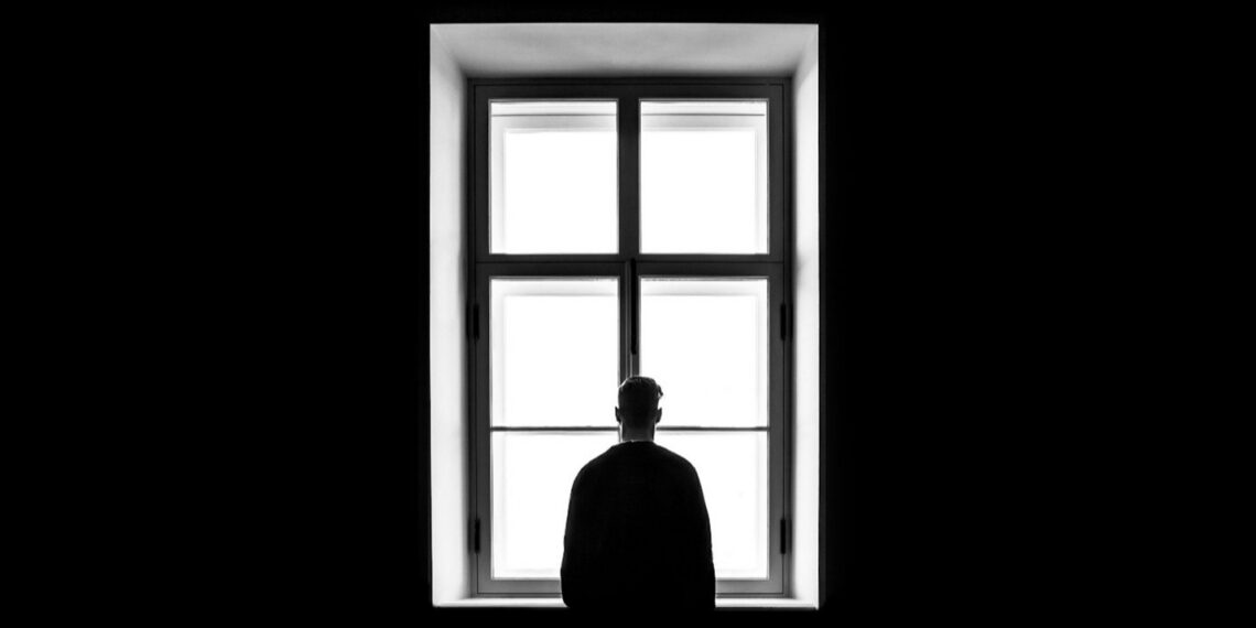 Man die uit het raam kijkt