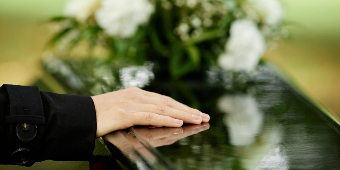 Hand op kist met bloemen