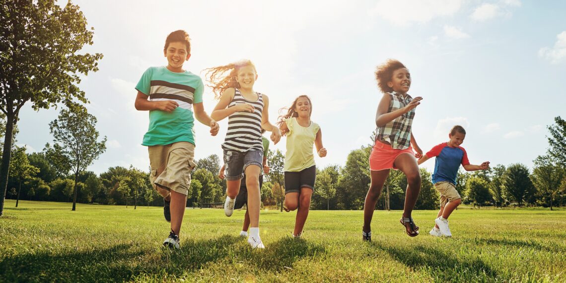 Rennende kinderen buiten in een grasveld