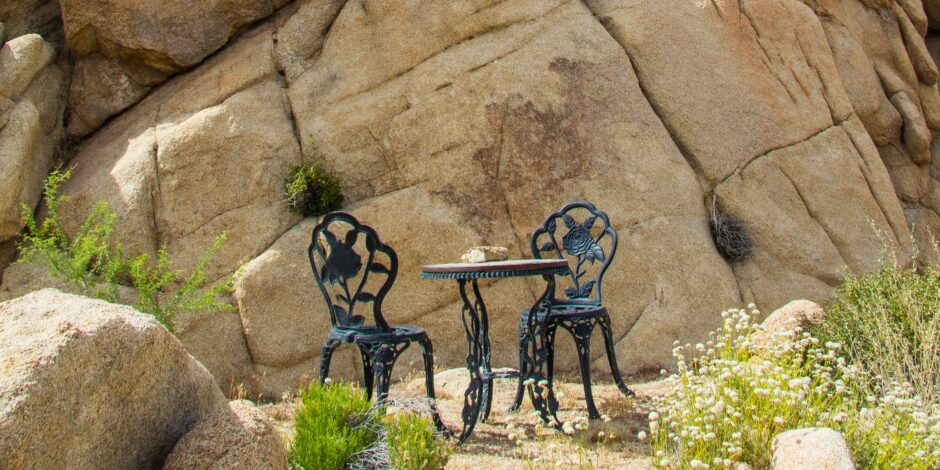 Tafel met daarop brood met twee stoelen eromheen midden in een woestijn