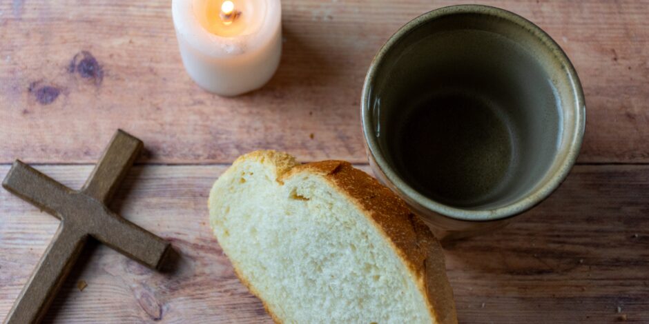 tafel met daarop een kruis, kaars, brood en een glas water