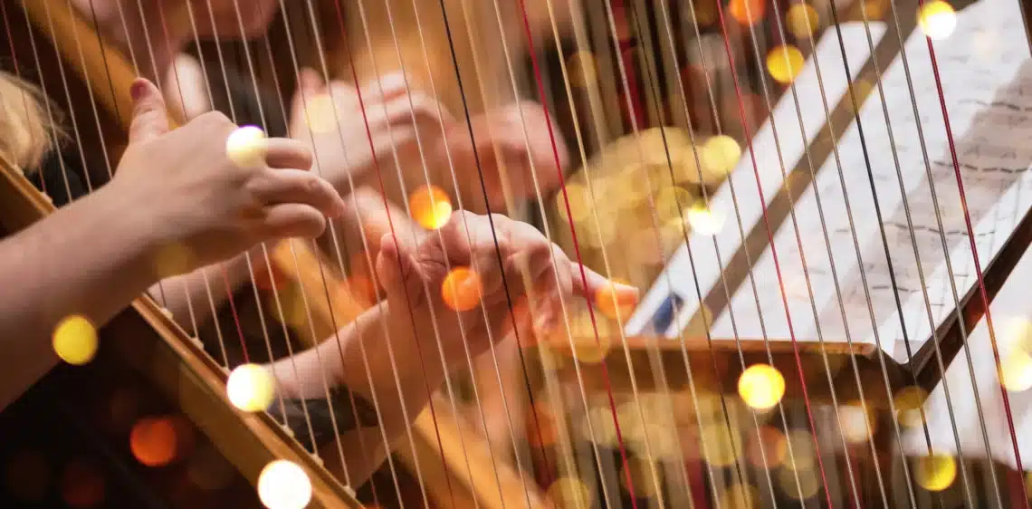 Handen van dichtbij die harp aan het spelen zijn