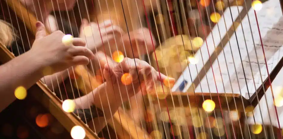 Handen van dichtbij die harp aan het spelen zijn