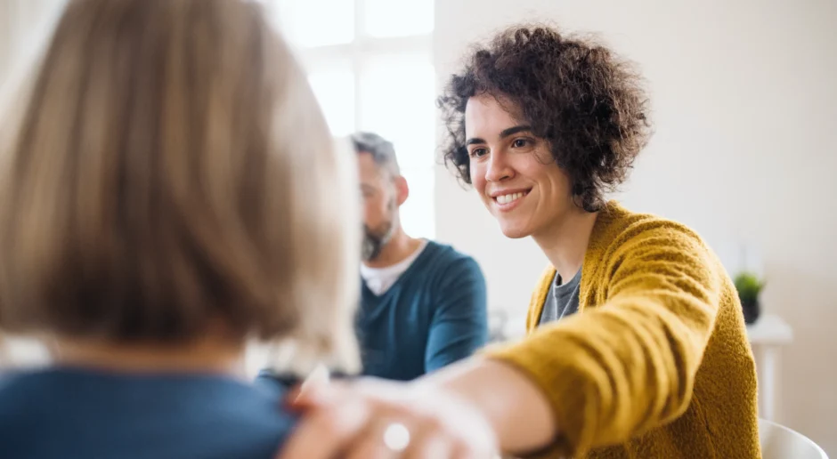 Mannen en vrouwen zitten in een cirkel tijdens groepstherapie, het ondersteunen van elkaar.