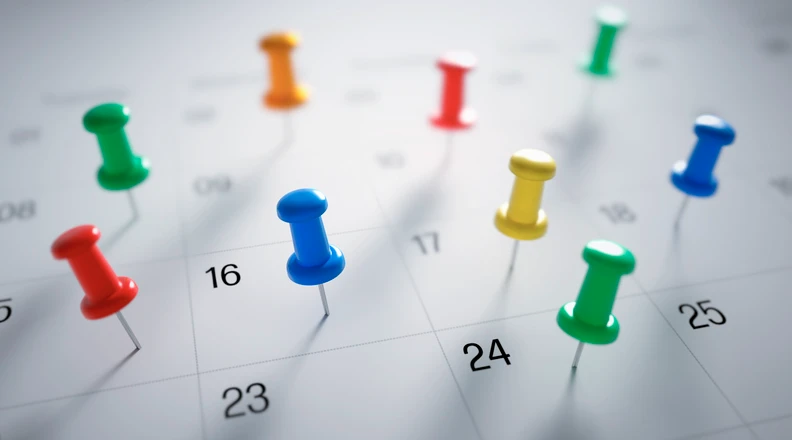 Gekleurde punaises in een agenda geprikt
