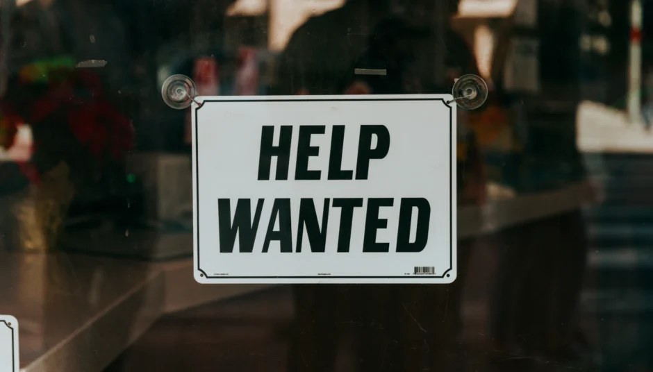 Een bordje met Help wanted op een ruit