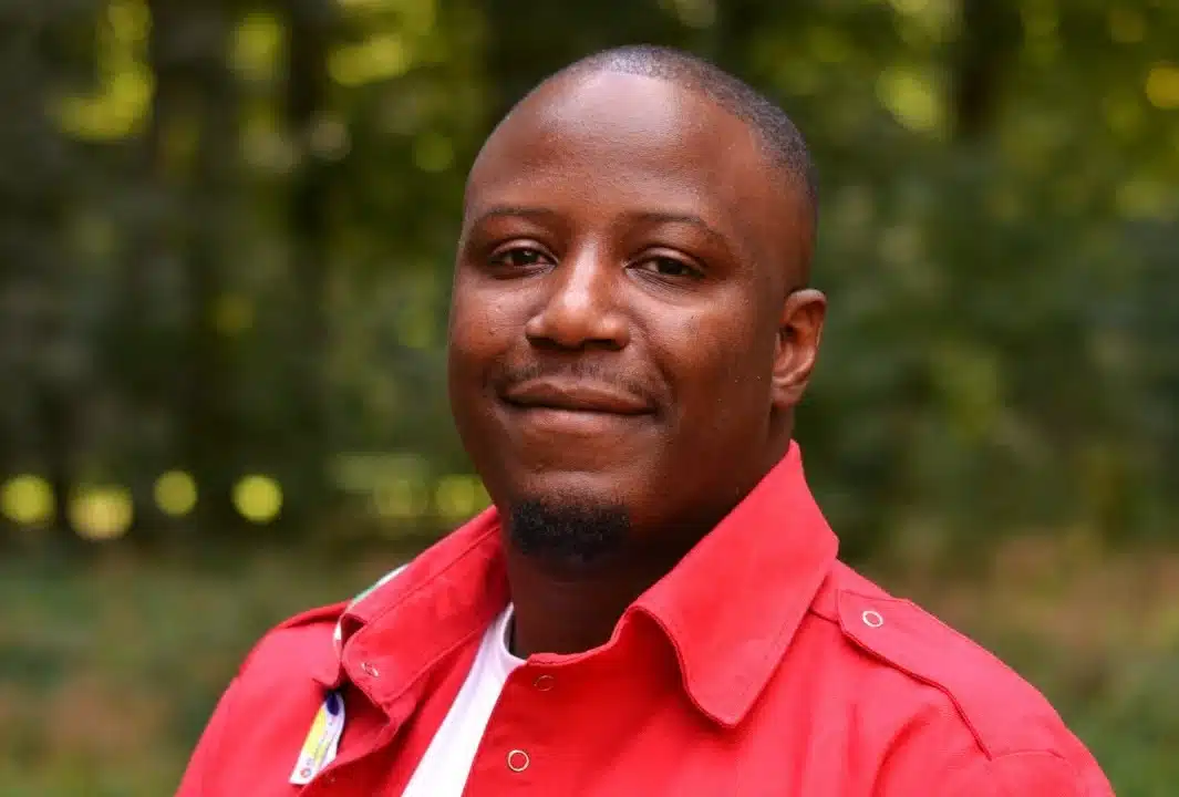 Portret van David Iboma, buiten voor een groene achtergrond