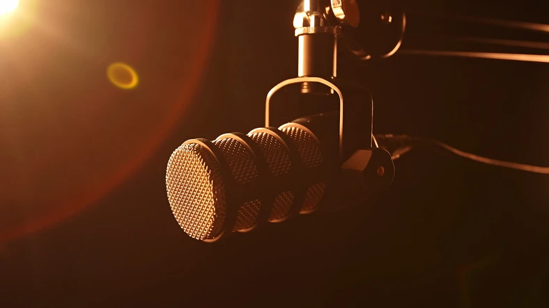 Beeld van een podcastmicrofoon in geel licht