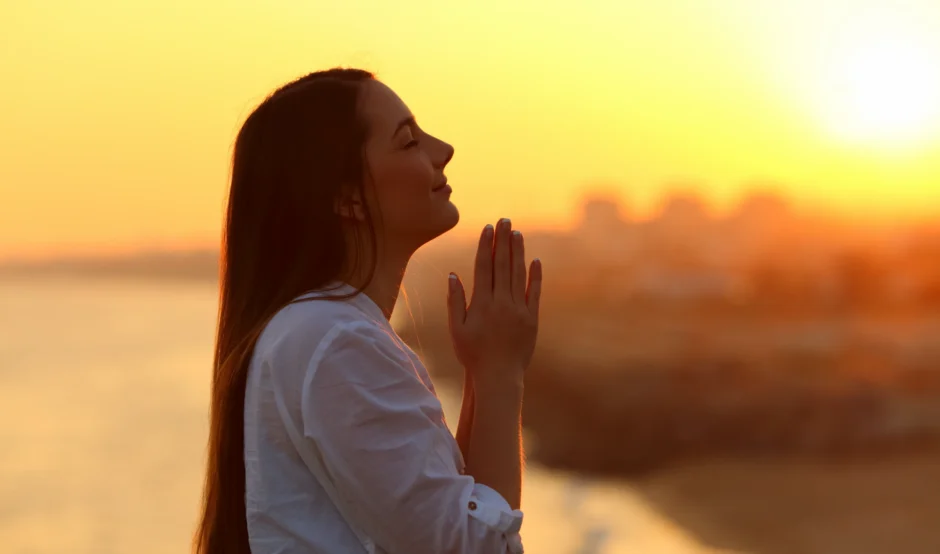 Biddende vrouw bij zonsondergang