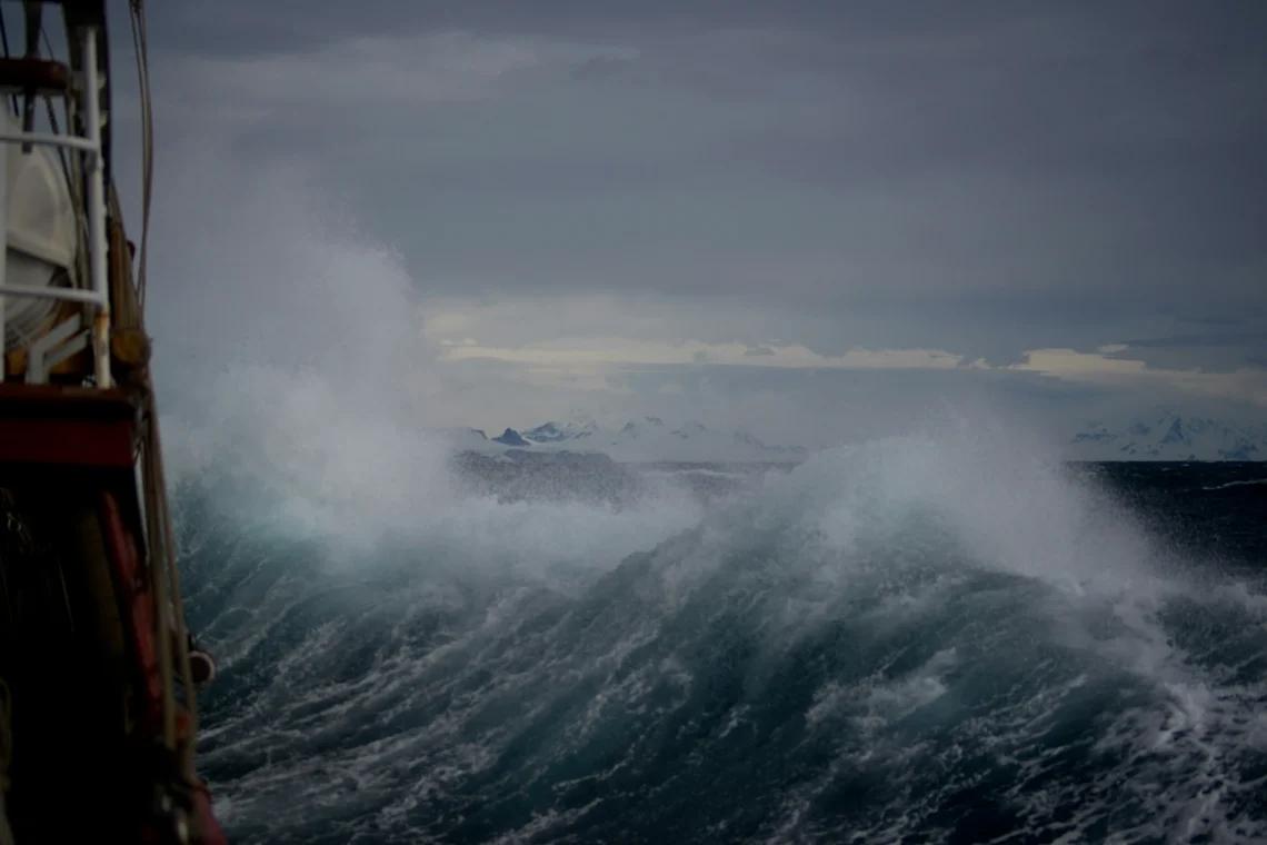 Storm op zee: hoge golven, grijze lucht.